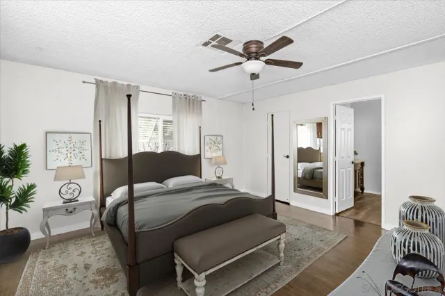 a bedroom with a bed a chandelier and a dresser