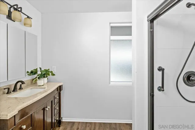 a bathroom with a granite countertop sink and a mirror