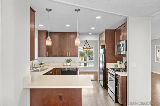 a kitchen with stainless steel appliances kitchen island granite countertop a sink and a refrigerator