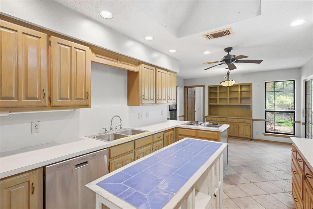 37 Timbergreen Circle Denton, TX 76205 - Photo 17 of 31 Kitchen featuring wood cabinetry, white countertops, a stainless steel dishwasher, a center island with a tiled surface, and recessed lighting