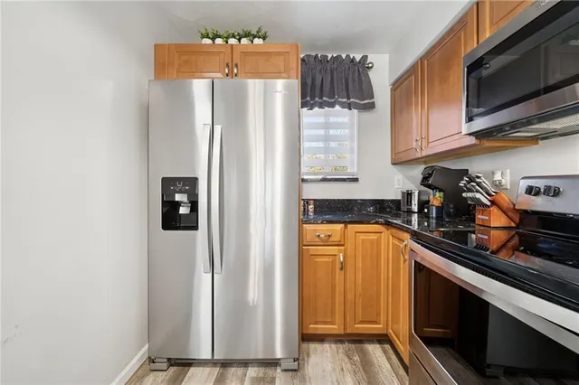 a kitchen with stainless steel appliances granite countertop a refrigerator and a sink