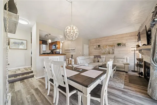 a view of a dining room with furniture a chandelier and wooden floor