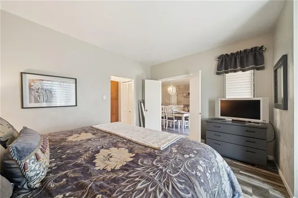 a bedroom with a large bed and wooden floor