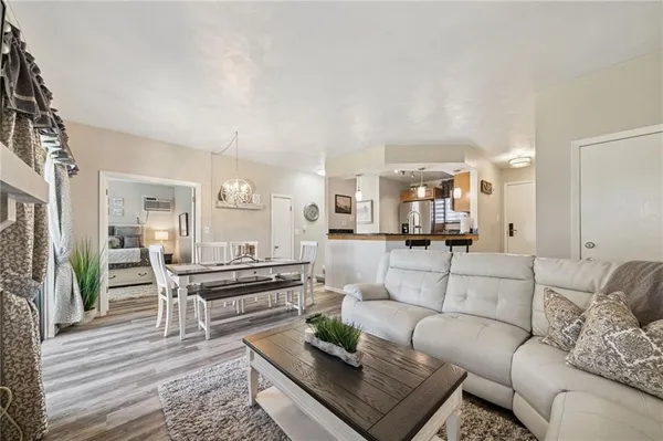 a living room with furniture wooden floor and kitchen view