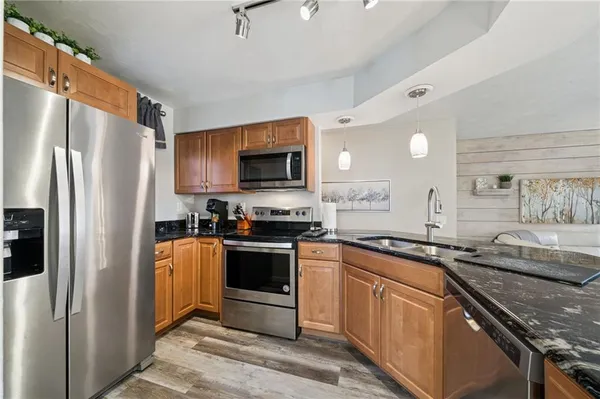 a kitchen with stainless steel appliances granite countertop a refrigerator stove microwave and sink