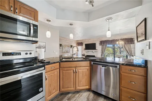a kitchen with granite countertop a sink stainless steel appliances and cabinets
