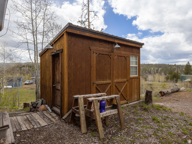 5082 Pine Crest Road Evanston, UT 82930 - Photo 6 of 25 Exterior shed featuring wood-finish siding, a single-pane window, and two barn-style doors