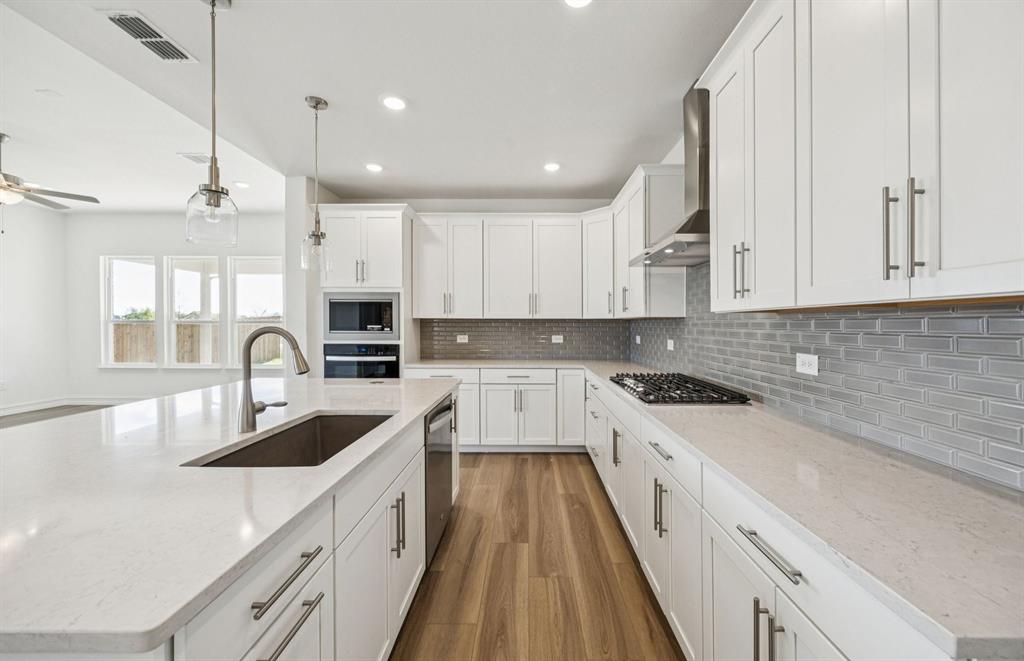 1232 Kadynce Lane Anna, TX 75409 - Photo 3 of 21 a kitchen with kitchen island granite countertop a sink stainless steel appliances and cabinets