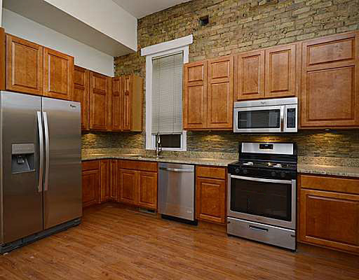 1645 West Irving Park Road Chicago, IL 60613 - Photo 6 of 33 a kitchen with stainless steel appliances granite countertop a refrigerator microwave and sink