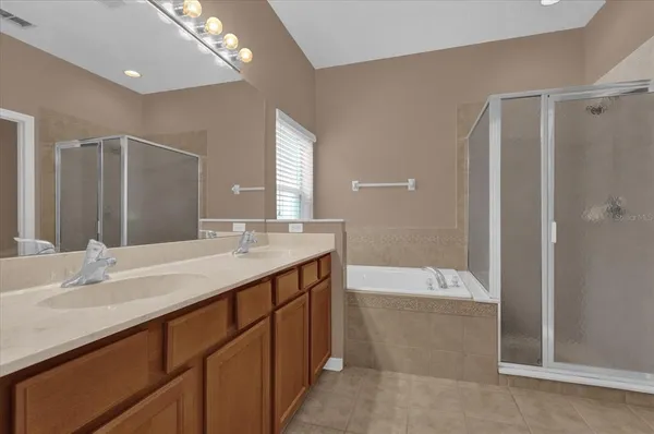 a bathroom with a granite countertop sink a bathtub a mirror and a shower