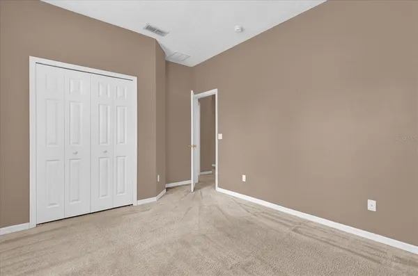 an empty room with closet and a bathroom
