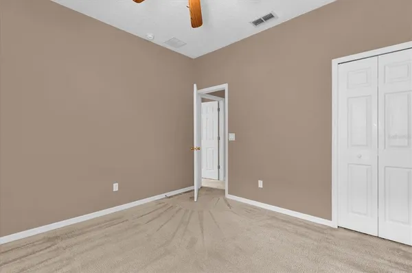 an empty room with closet and windows