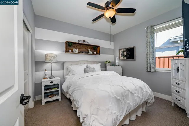 a bedroom with a bed a chandelier and a window