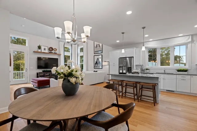 a view of a dining room with furniture a chandelier and wooden floor
