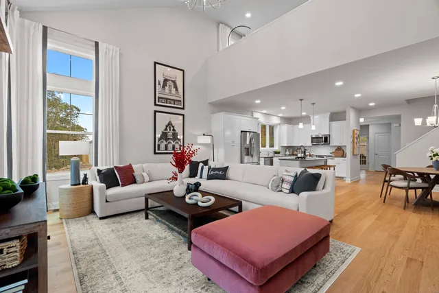 a living room with furniture a wooden floor and a large window