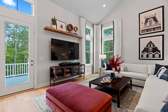 a living room with furniture a flat screen tv and a large window