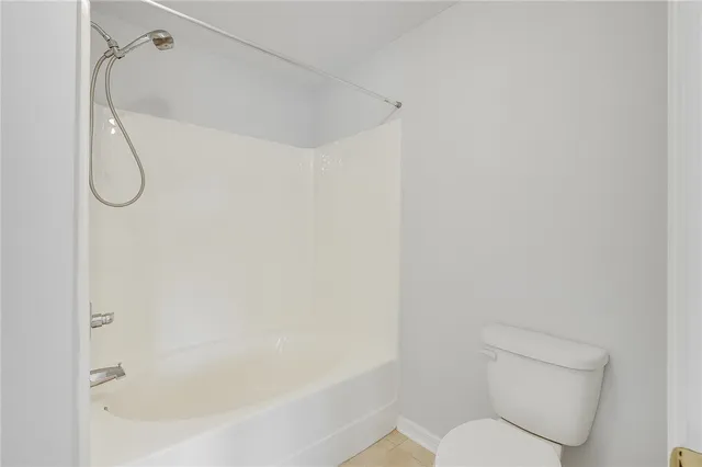 a white toilet sitting next to a bath tub and shower