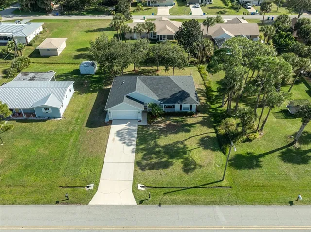 an aerial view of a house with a yard basket ball court and outdoor seating