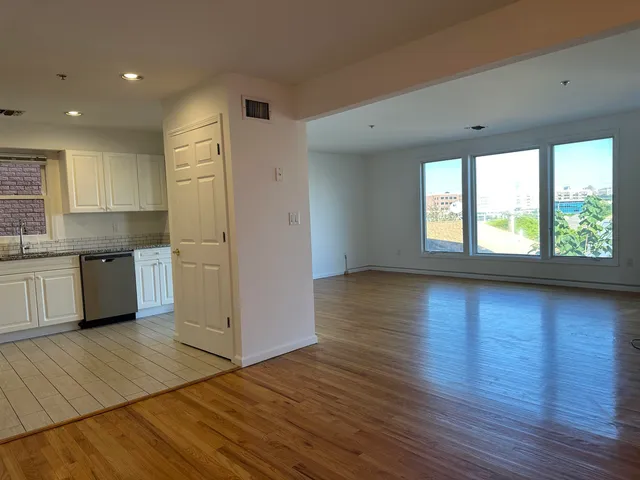 a view of a kitchen with wooden floor and a window