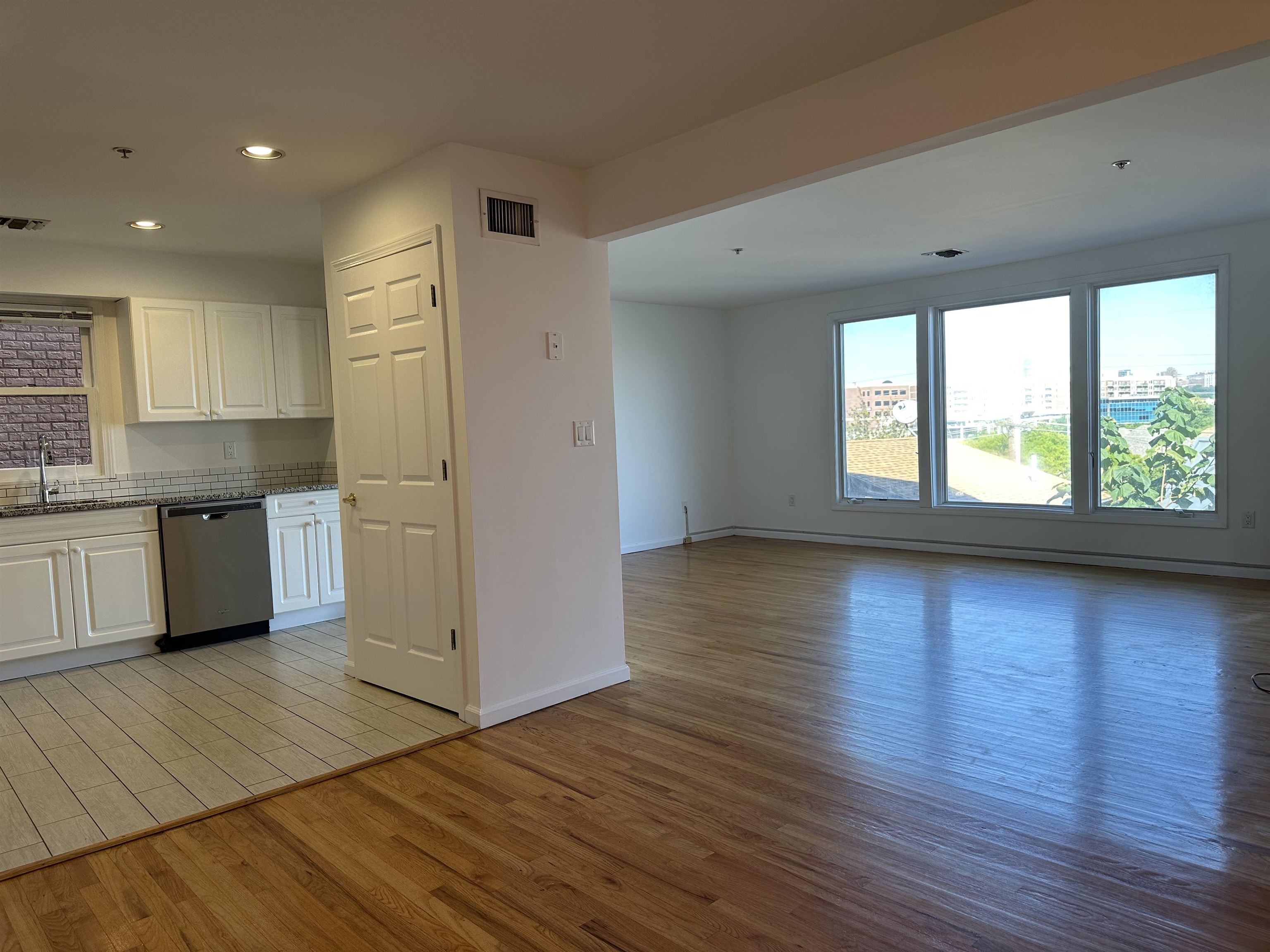 a view of a kitchen with wooden floor and a window