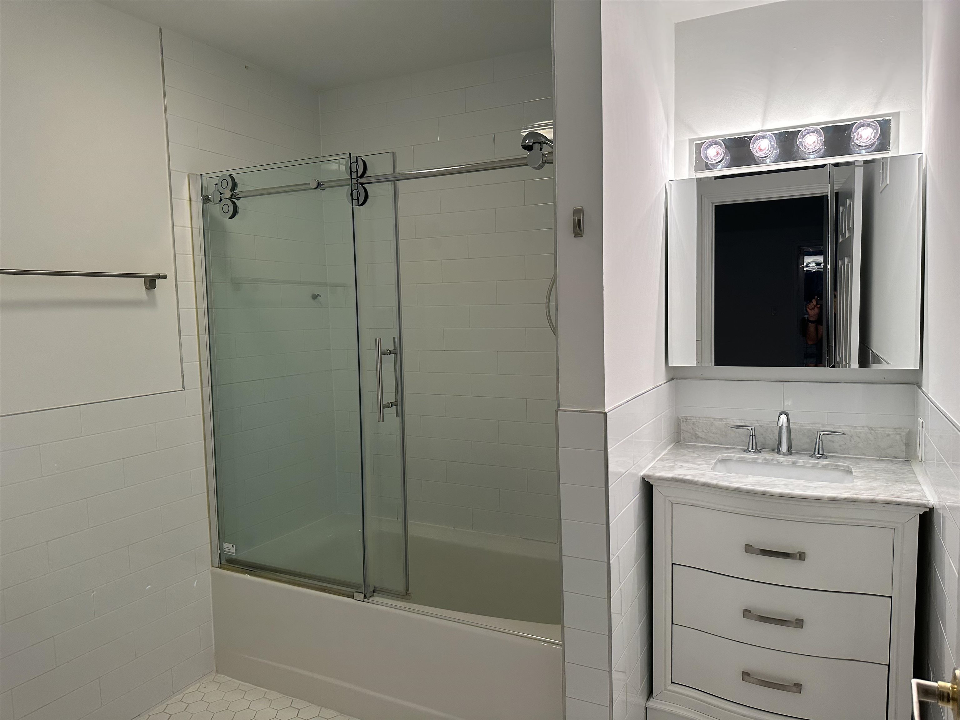 8911 Riverside Place, Unit 1 North Bergen, NJ 07047 - Photo 12 of 18 a bathroom with a shower sink and mirror