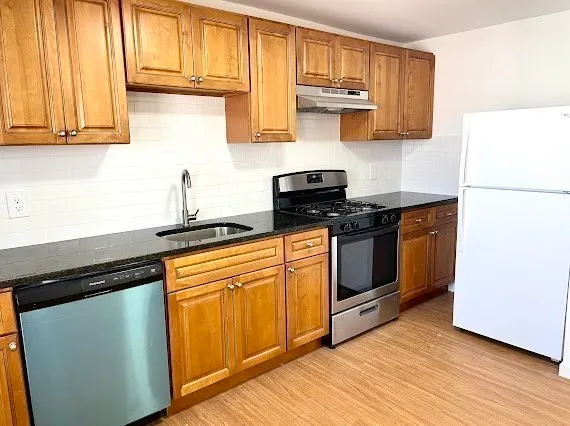 a kitchen with stainless steel appliances granite countertop a stove a sink and a microwave