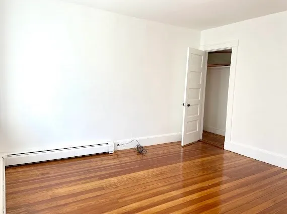 a view of an empty room with wooden floor