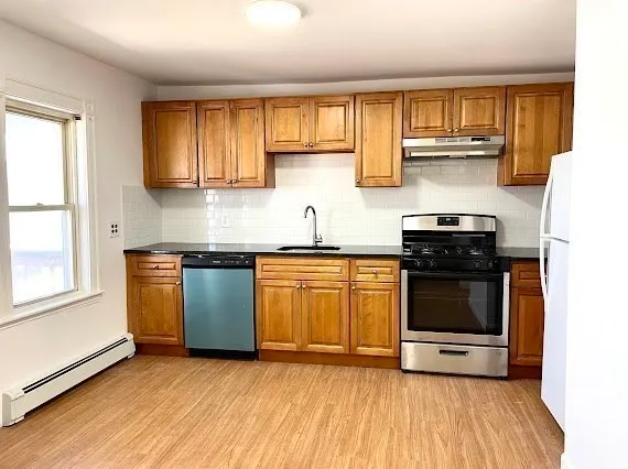 a kitchen with stainless steel appliances granite countertop a stove a sink and a microwave
