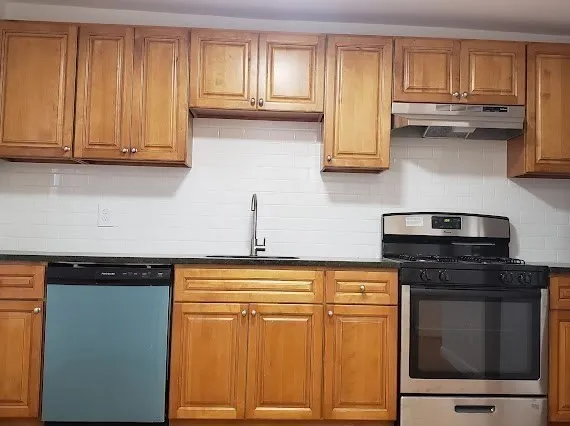 a kitchen with stainless steel appliances granite countertop wooden cabinets and a stove top oven