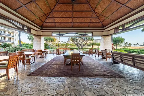 a outdoor space with lots of tables a large window and chairs