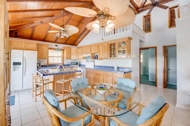 a dining room with furniture a kitchen view and chandelier
