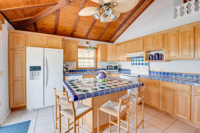 a kitchen with stainless steel appliances granite countertop a table chairs and a refrigerator