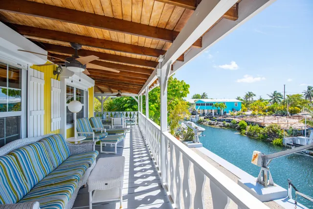 a view of a balcony with chairs and potted plants