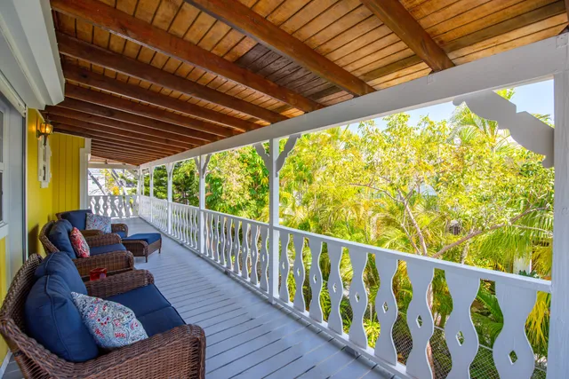 a balcony with wooden floor and outdoor seating