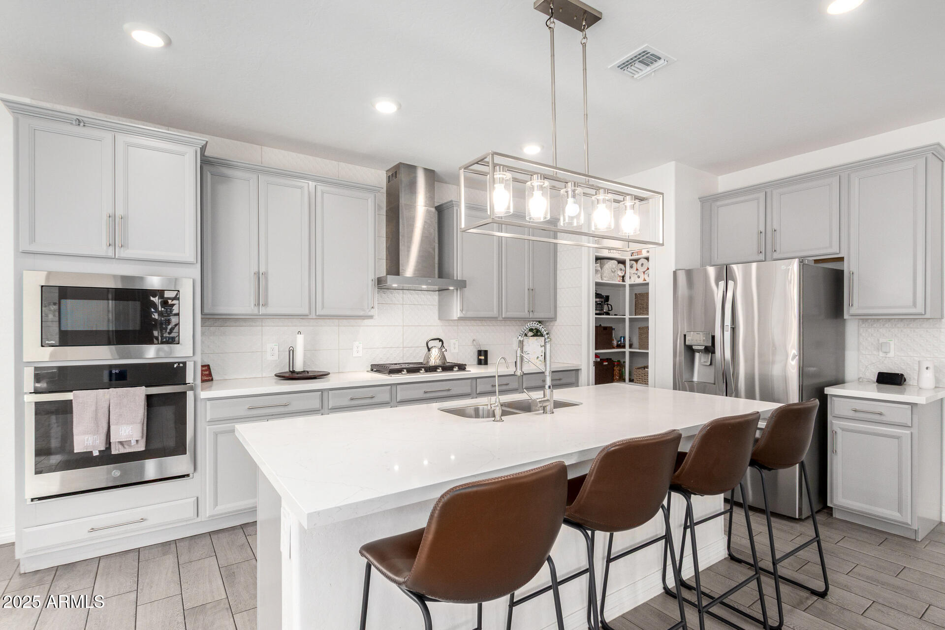 10029 East Tahoe Avenue Mesa, AZ 85212 - Photo 11 of 52 a kitchen with stainless steel appliances a stove a sink island and a refrigerator