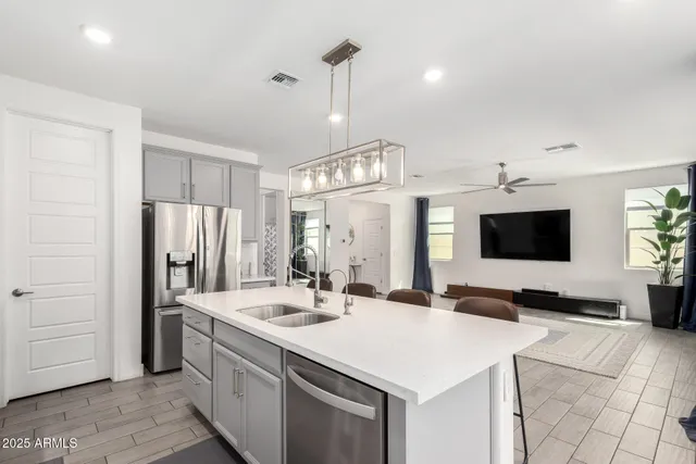 a kitchen with stainless steel appliances a stove a sink and a refrigerator