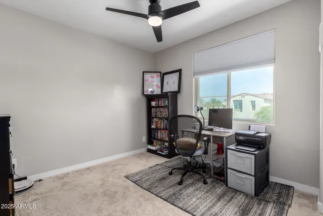 a view of a workspace with furniture and a window