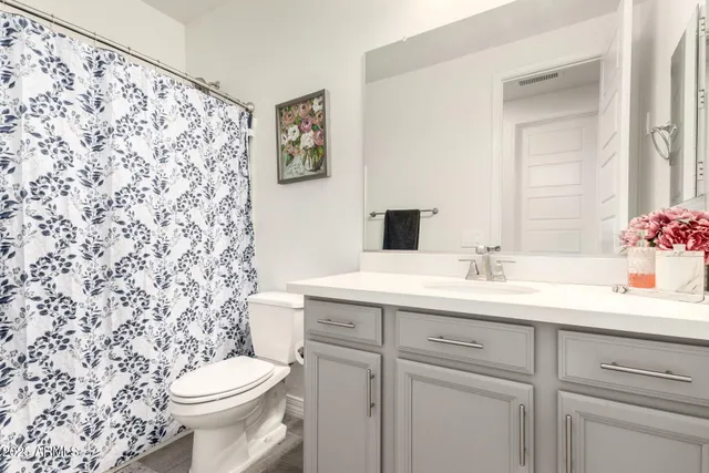 a bathroom with a granite countertop sink and a toilet