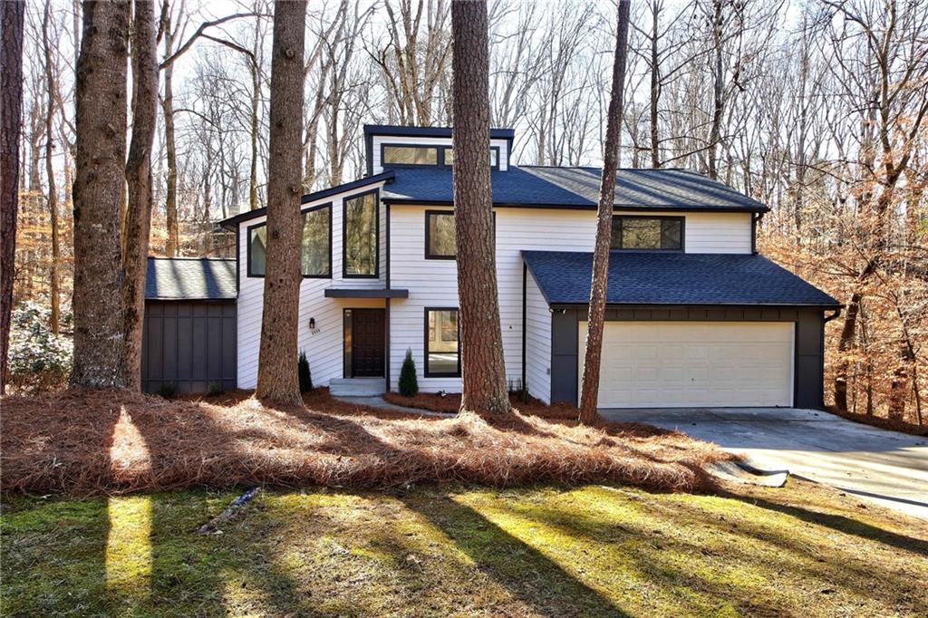 8960 Martin Road Roswell, GA 30076 - Photo 1 of 1 a view of a house with a small yard plants and large tree