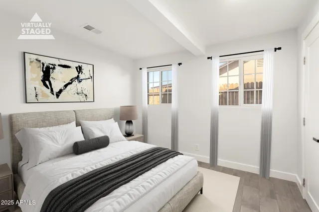 a bedroom with bed and wall painting with wooden floor