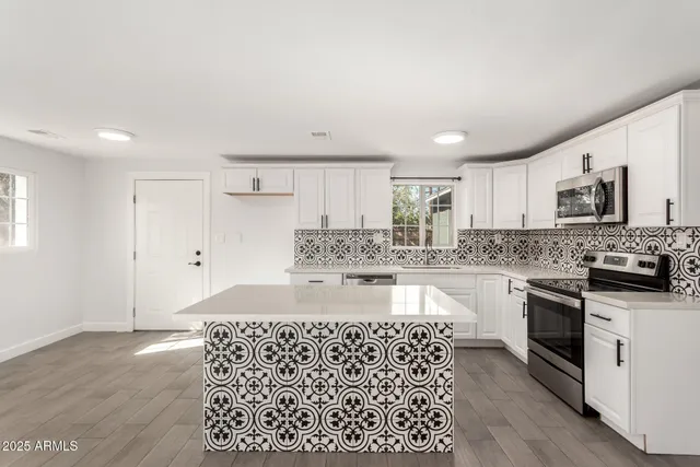 a kitchen with stainless steel appliances granite countertop a sink stove and refrigerator