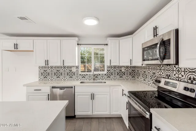 a kitchen with granite countertop a sink stove and cabinets