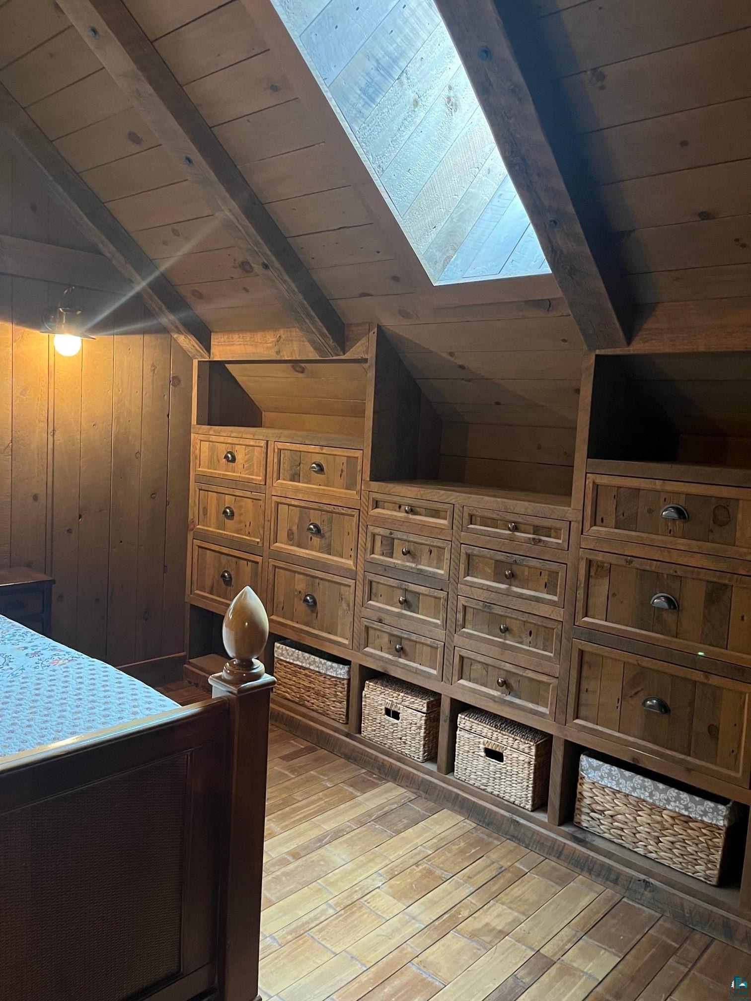 70745 Range Line Road Iron River, WI 54847 - Photo 23 of 40 Wood-paneled sloped ceiling with exposed beams, skylight, and integrated storage cabinetry