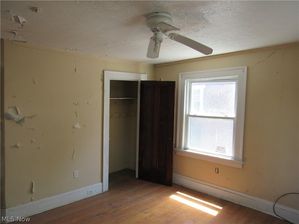 1726 Lee Road Cleveland Heights, OH 44118 - Photo 27 of 36 Room featuring wood-finish flooring, a double-hung window with white trim, and a ceiling fan