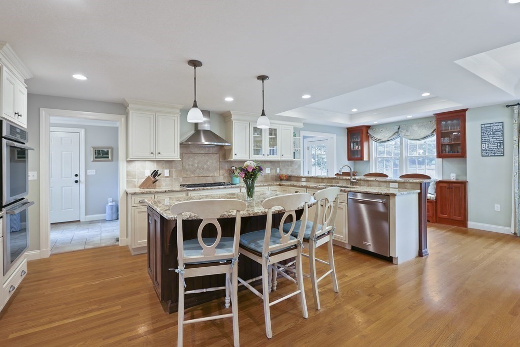60 Colby Street Needham, MA 02492 - Photo 13 of 41 a kitchen with stainless steel appliances kitchen island granite countertop a table chairs sink and cabinets