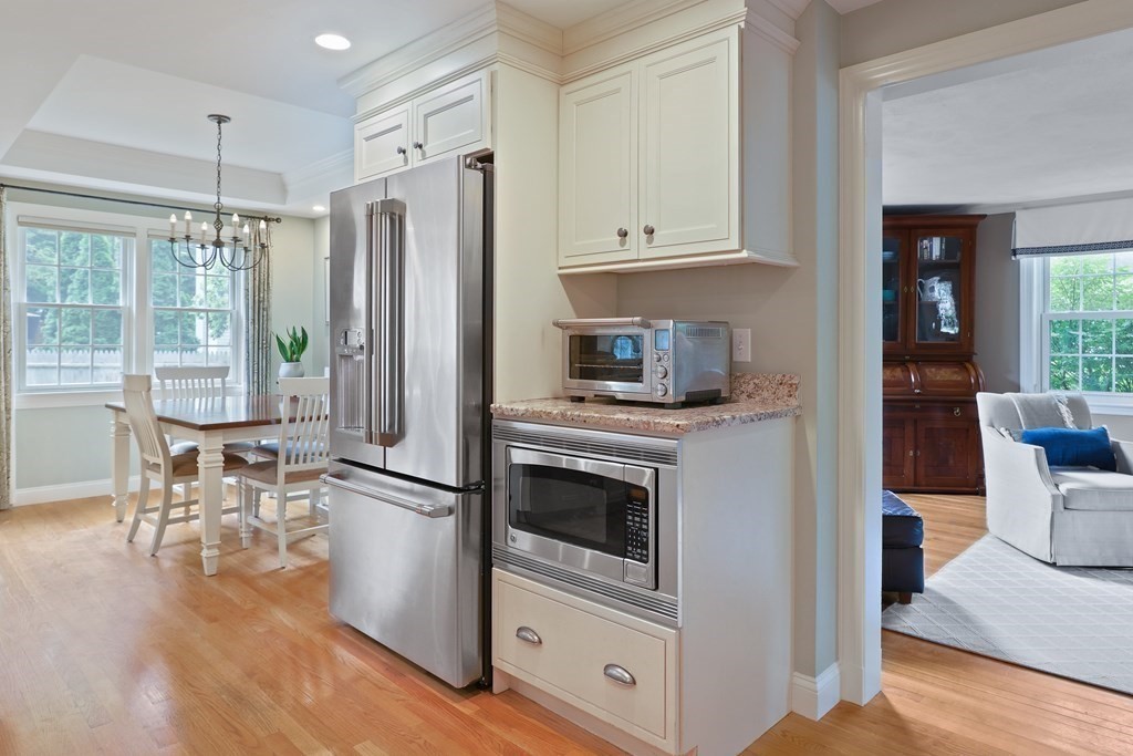 60 Colby Street Needham, MA 02492 - Photo 15 of 41 a kitchen with stainless steel appliances a stove a refrigerator and a dining table with wooden floor