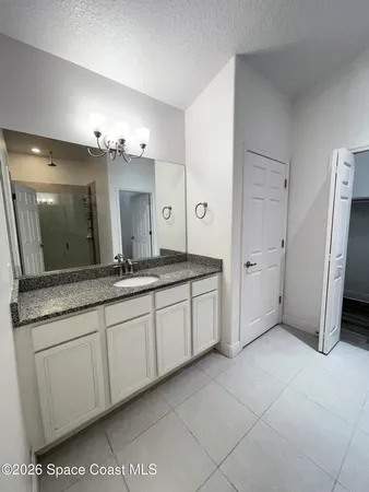 a spacious bathroom with a granite countertop sink mirror and cabinets