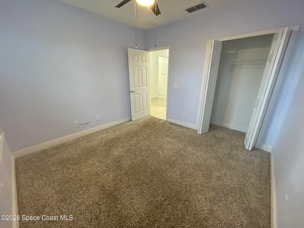 an empty room with windows and closet
