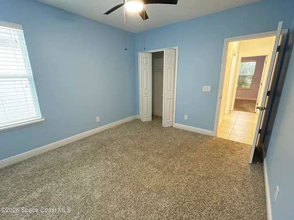 an empty room with windows and closet