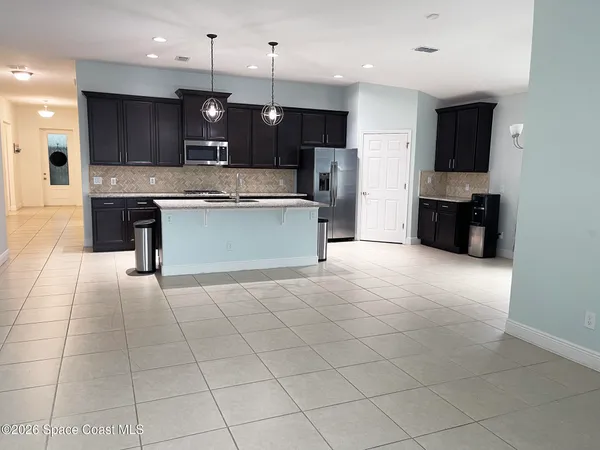 a large kitchen with a large counter top stainless steel appliances and cabinets